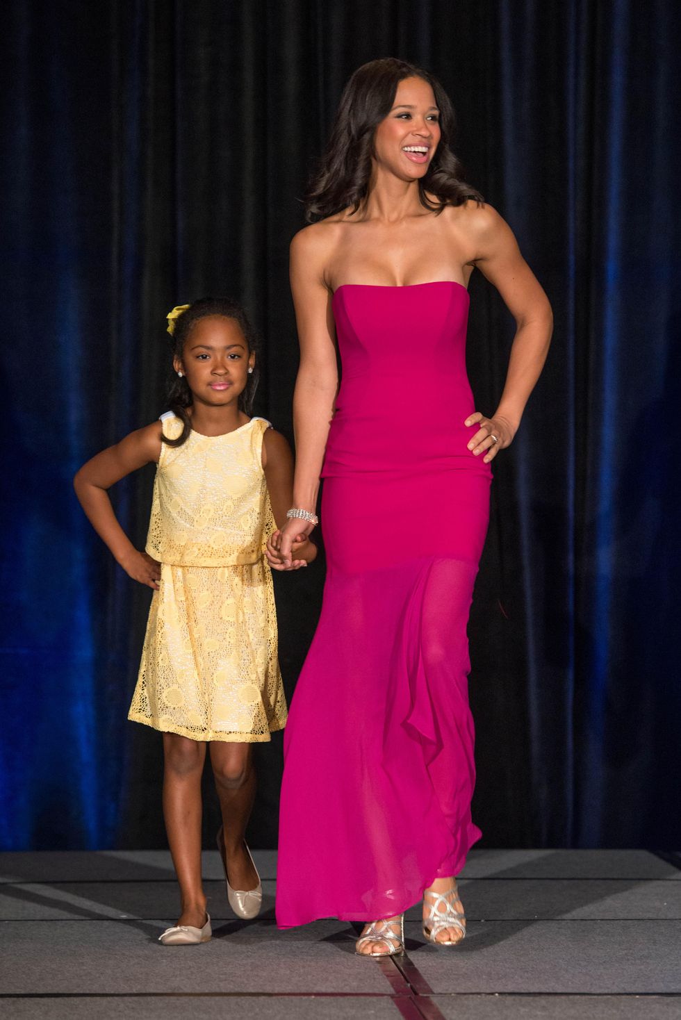 Mia Gradney walks the runway with a young friend. - CultureMap Houston