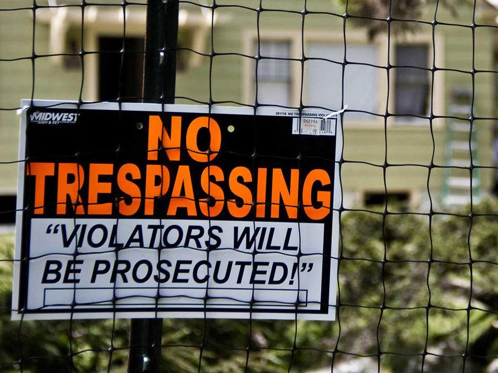 No Trespassing Violators will be prosecuted sign on fence