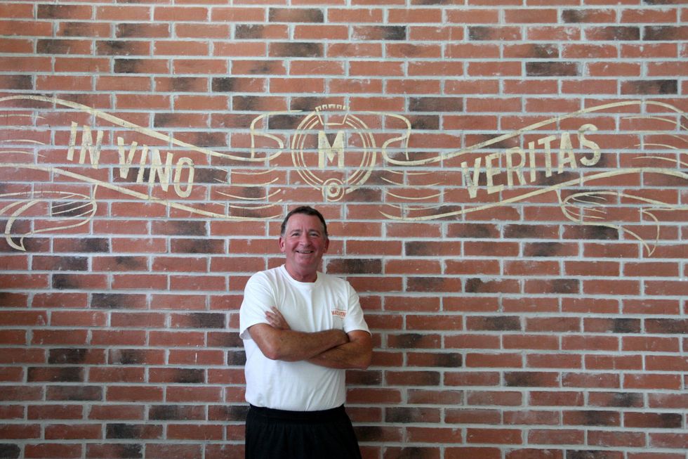 Osteria Mazzantini with John Sheely standing in front of mural