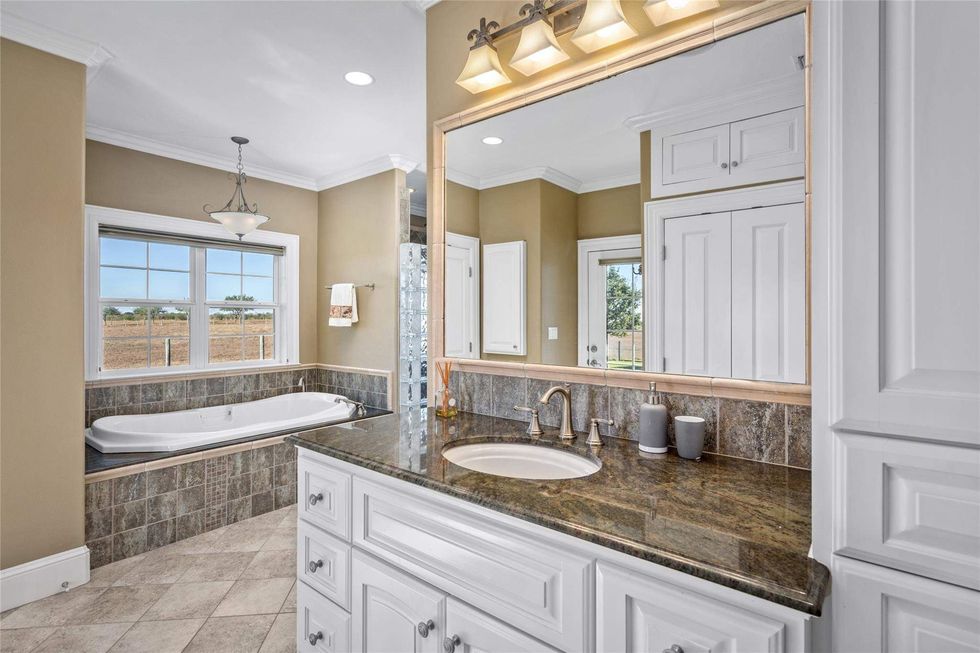 Owner's suite spa bathroom of Rocking C Ranch at 2740 Flewellen Road with a tub that has ranch views