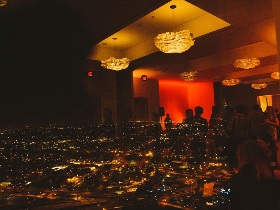 Party reflection in window against city-scape backdrop at Houston Symphony Young Professionals Backstage's Luck be a Lady event November 2013