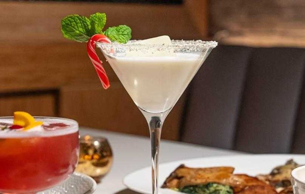 Photo of a cocktail beside a dinner dish