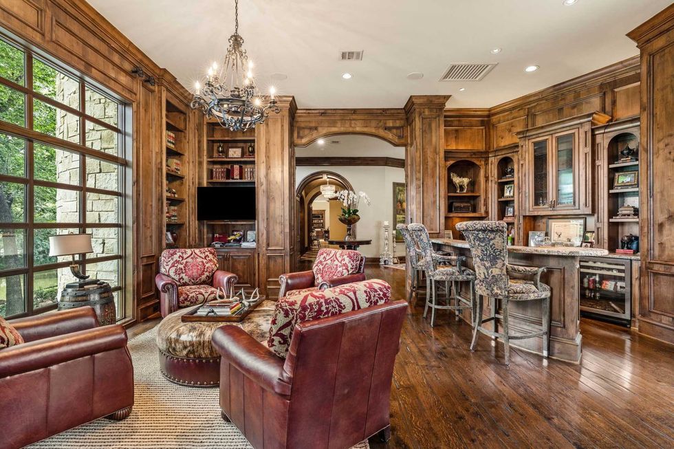 Picture of a wet bar and clubby leather chairs with wooded views out the window of 50 Patti Lynn Lane