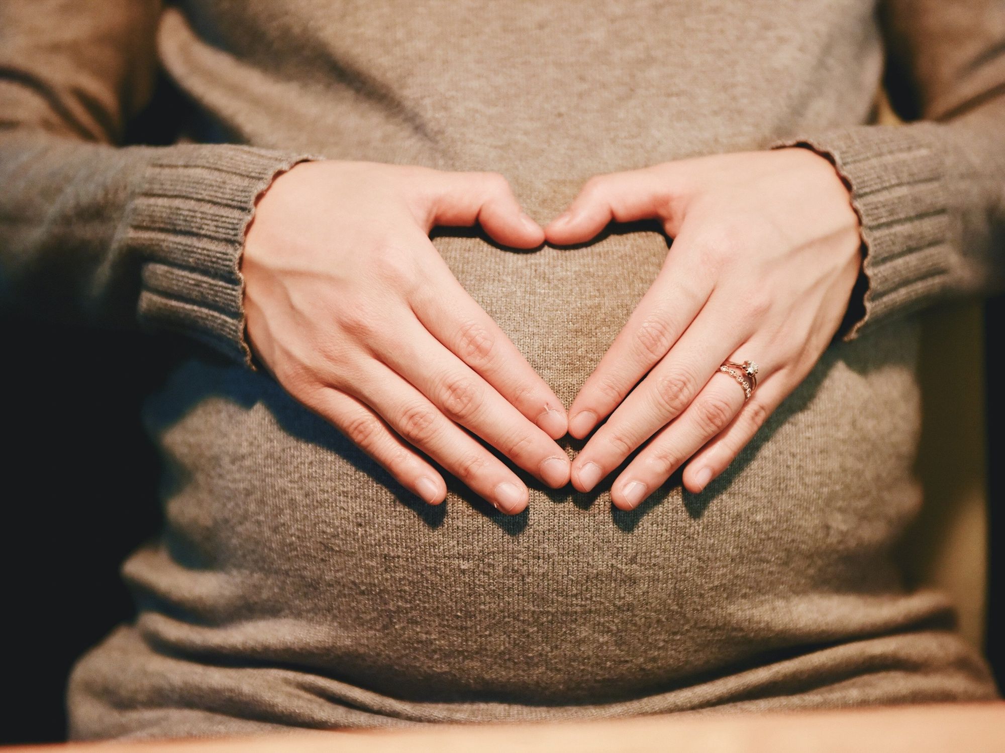 pregnant woman heart sign hands