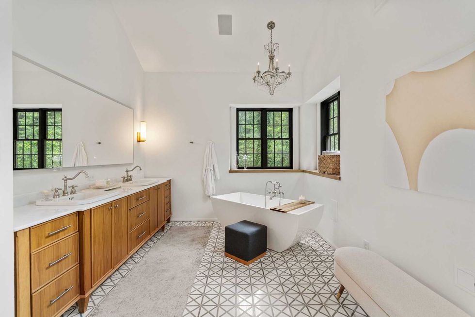 Primary suite bathroom of 23277 Brownwood Lane with tile floors, a soaking tub, and a window behind the tub