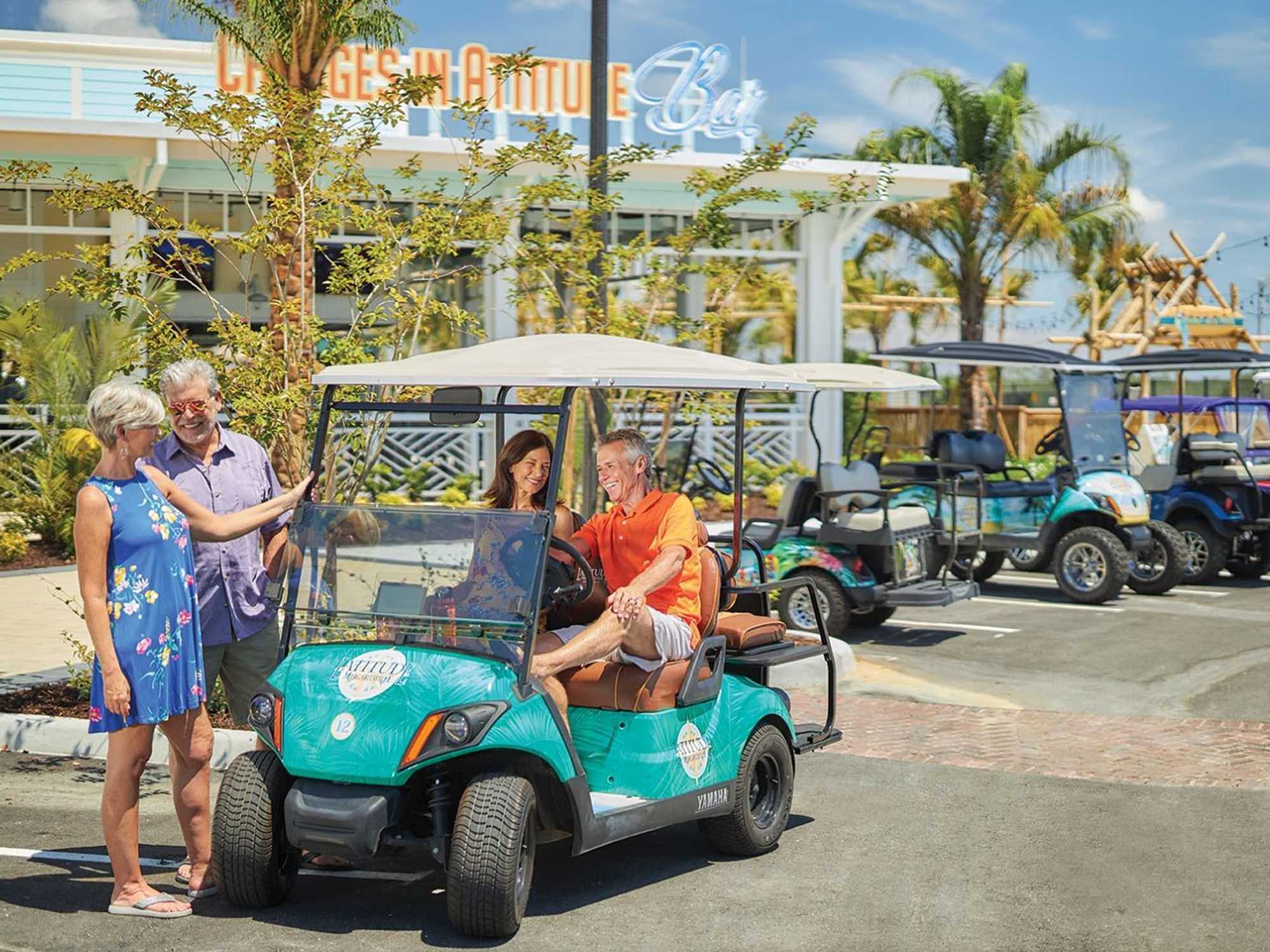 Residents of a Latitude Margaritaville community riding golf carts.