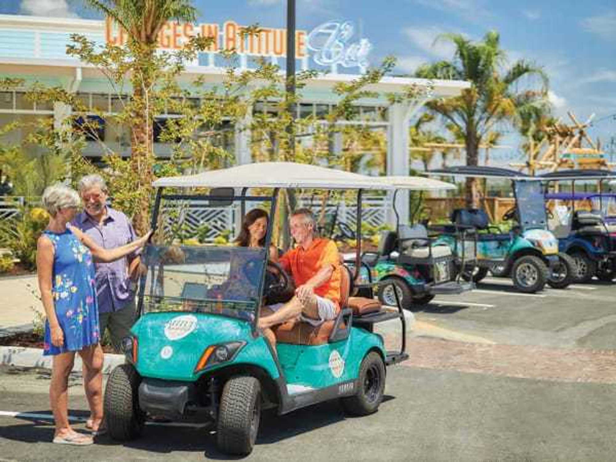 Residents of a Latitude Margaritaville community riding golf carts.