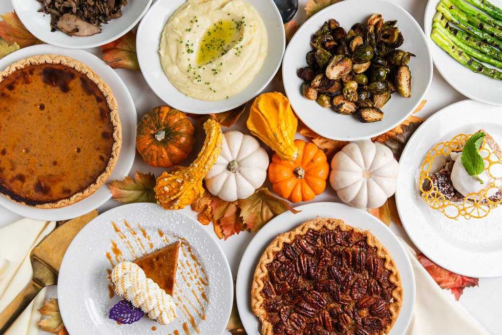 Selection of Thanksgiving pies, mashed potatoes, Brussels sprouts and asparagus.