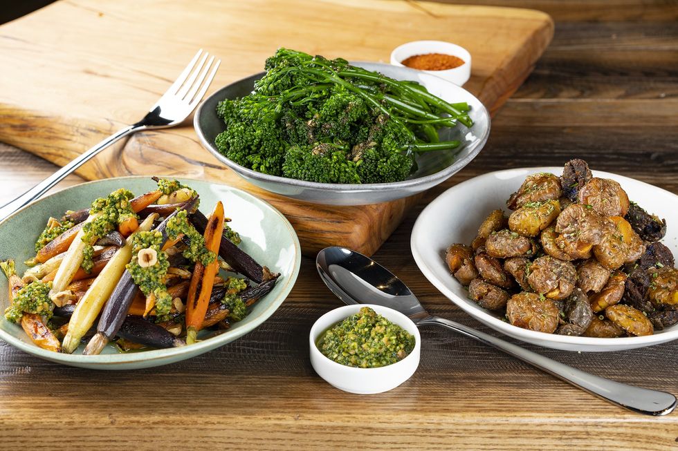 Side dishes from Warehouse 72: a plate of broccoli, a bowl of roasted potatoes and a bowl of carrots,
