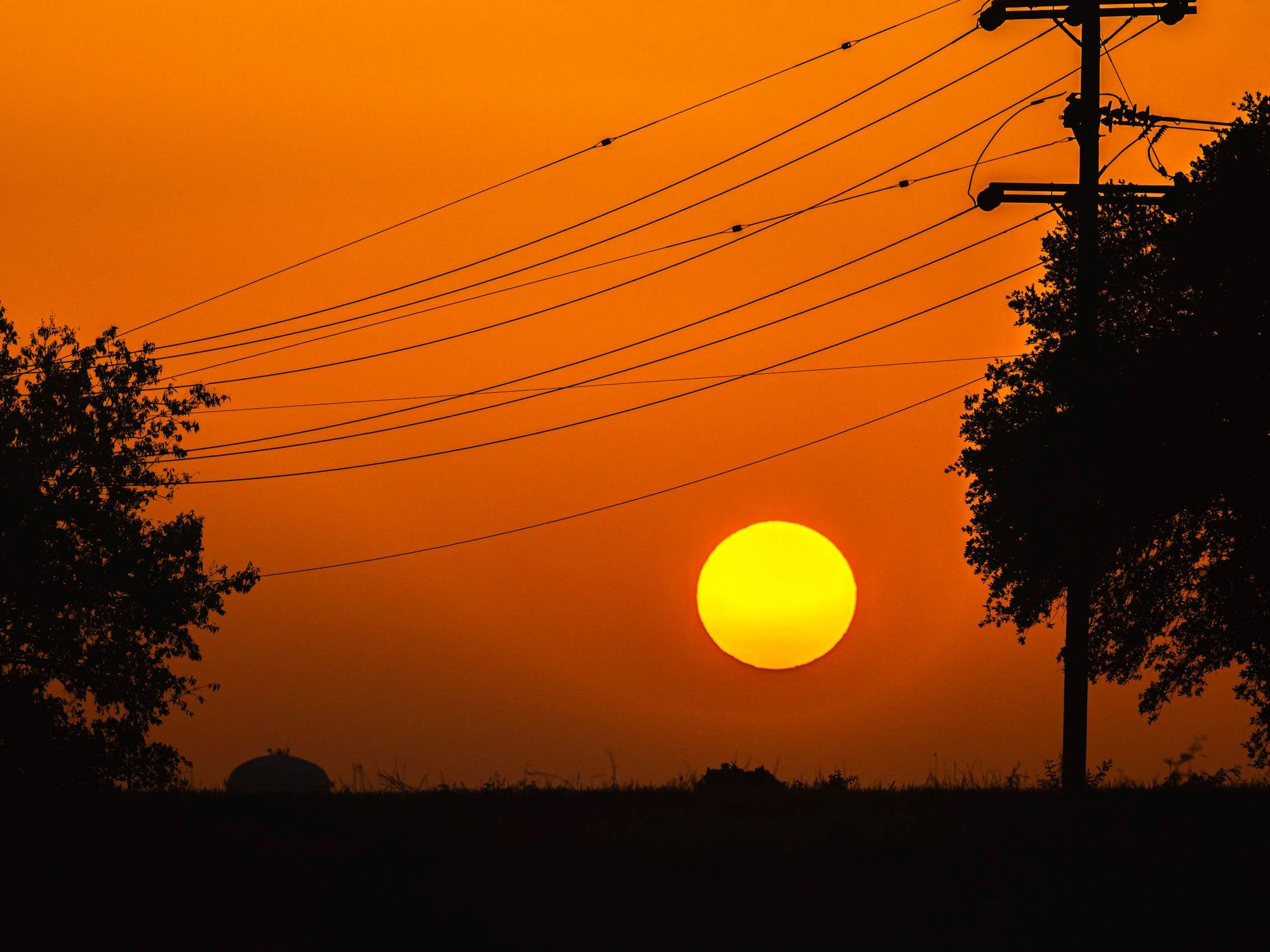 Silhouette of electricity pylon against orange sky,San Antonio,Texas,United States,USA