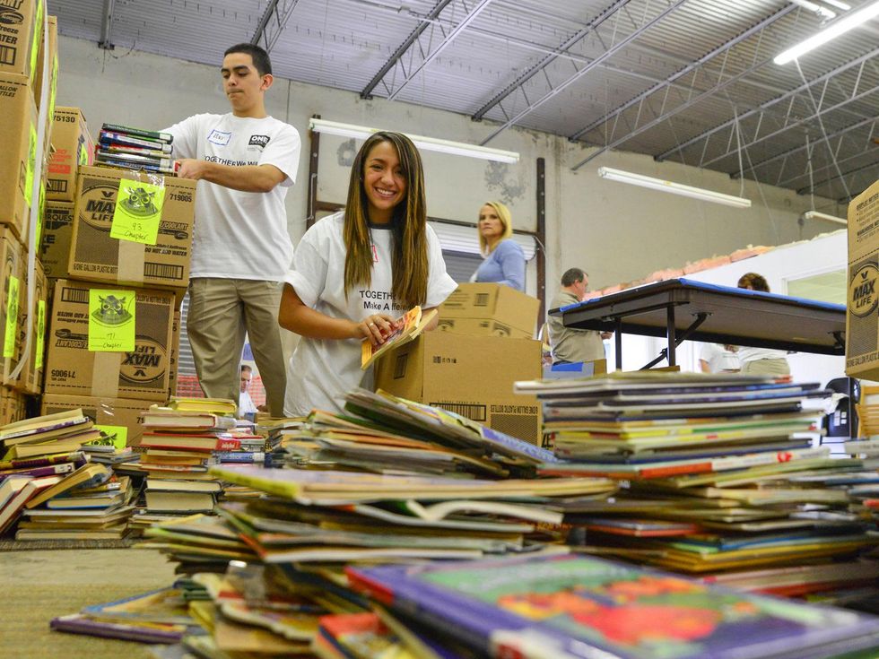 Students from Sharpstown International High School in HISD sort books at the Books Between Kids warehouse