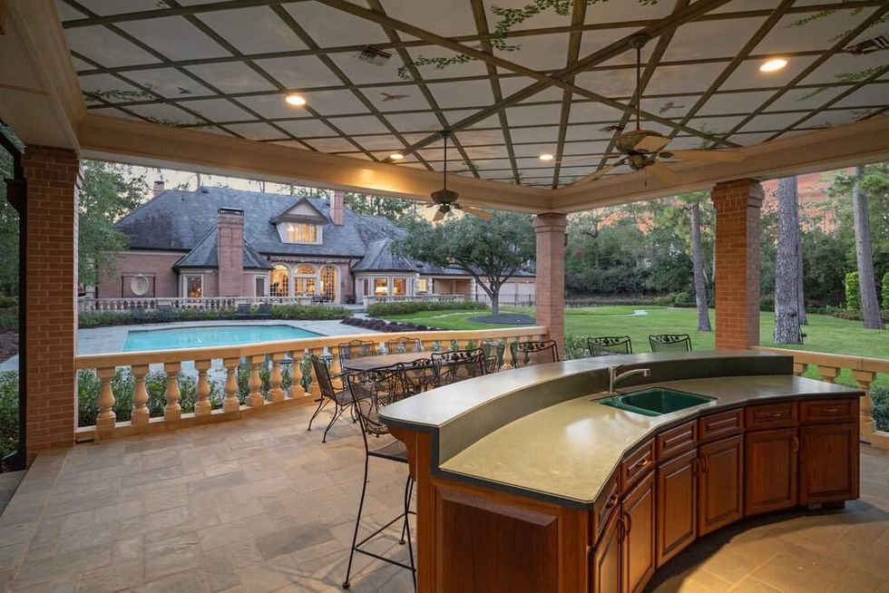 Summer kitchen overlooking the pool of 412 Timberwilde Lane
