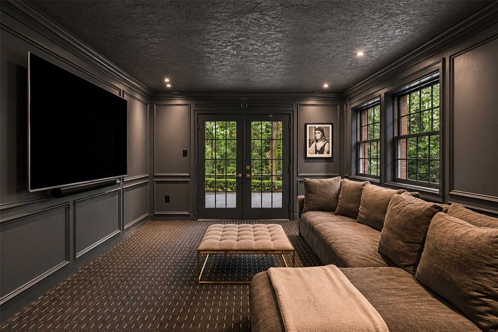 The movie room of 23227 Brownwood Lane in Tomball with French doors, a big-screen TV, and recessed lighting