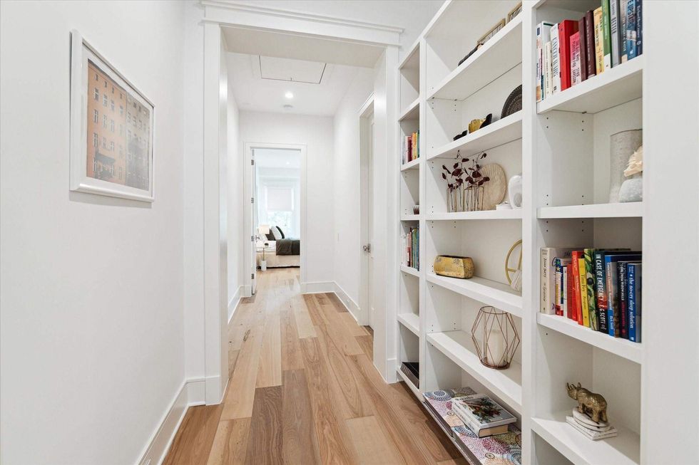 The upstairs corridor of 1039 Harvard Street, with built-in bookshelves on the right.