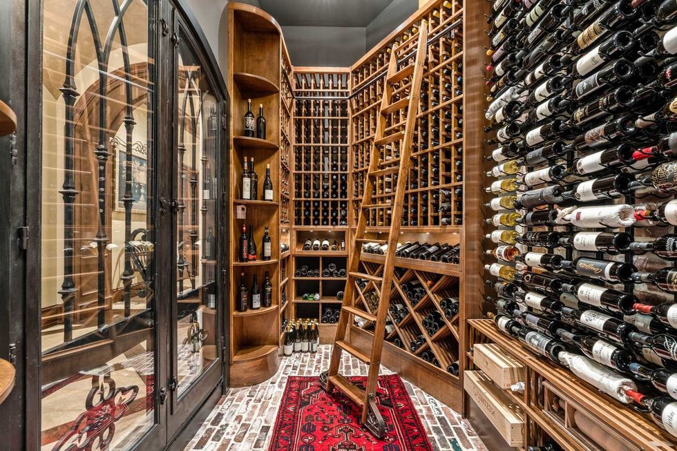 The wine room of 50 Patti Lynn Lane showing brick floors, a ladder and shelving space for 1,500 bottles