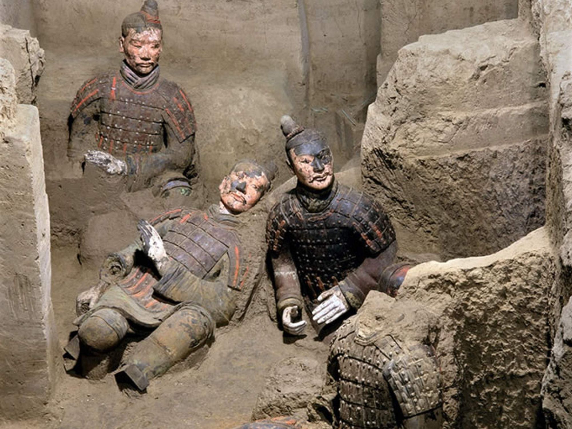 Three Chinese Terracotta Warriors amid an archeological dig.