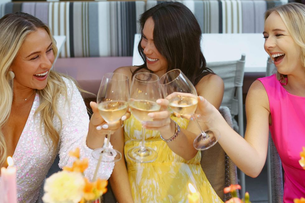 Three women toasting with wine glasses