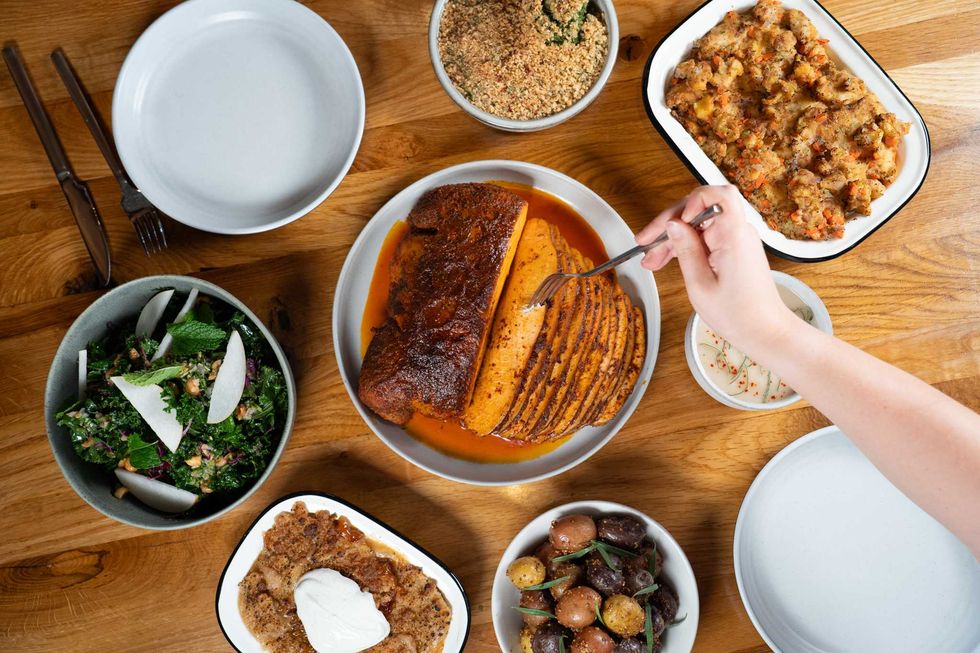 Turkey and side dishes with a hand sticking a form in the turkey