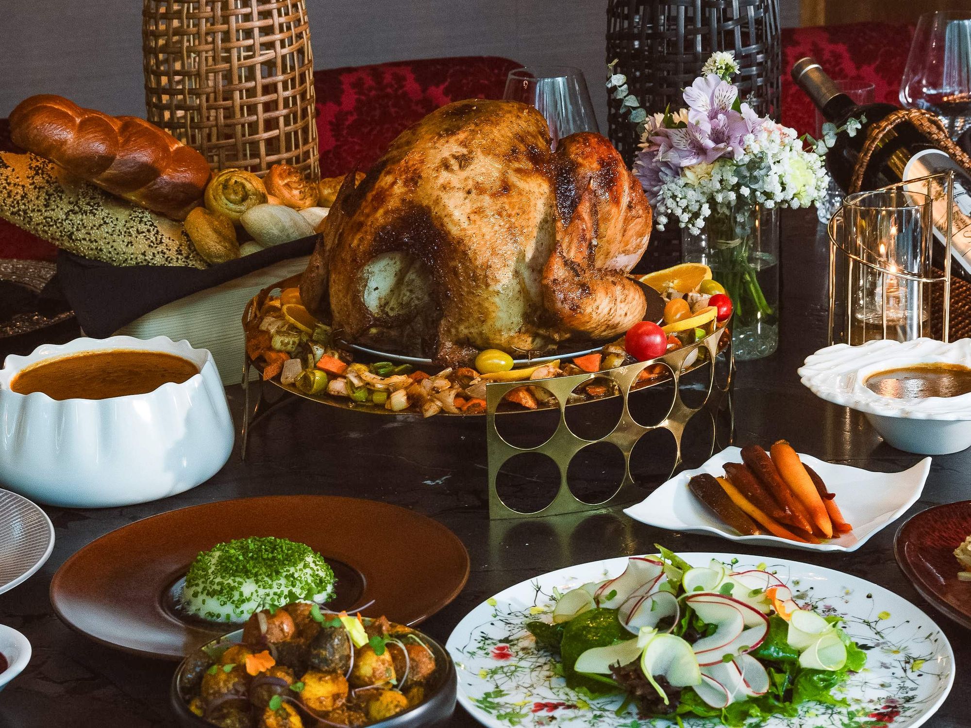 Turkey on a raised platter surrounded by side dishes.