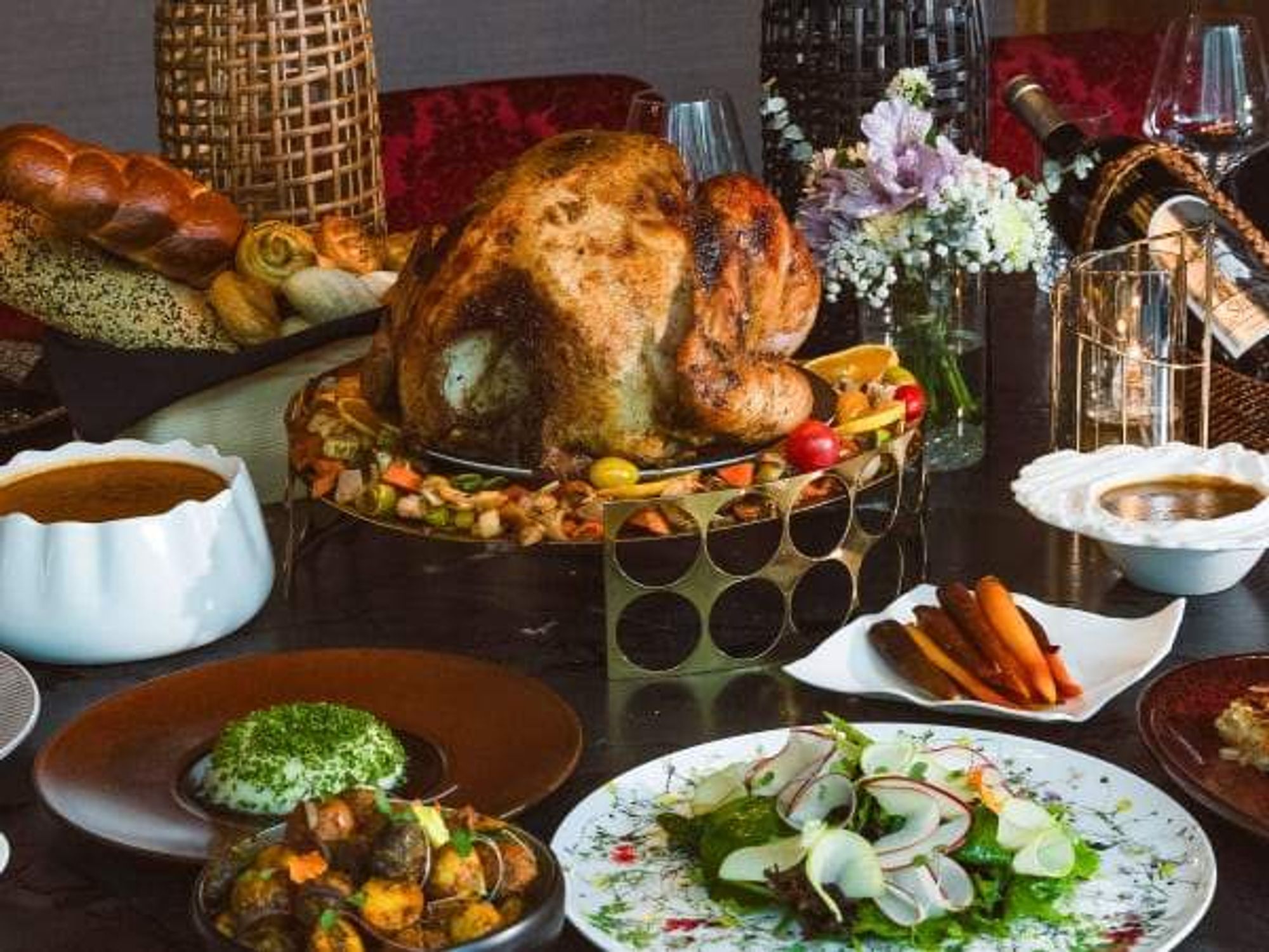 Turkey on a raised platter surrounded by side dishes.