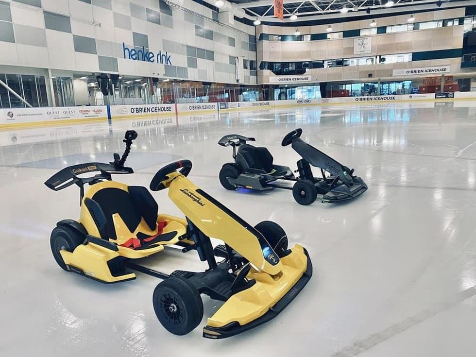 Two Go-Karts sit on an ice skating rink.
