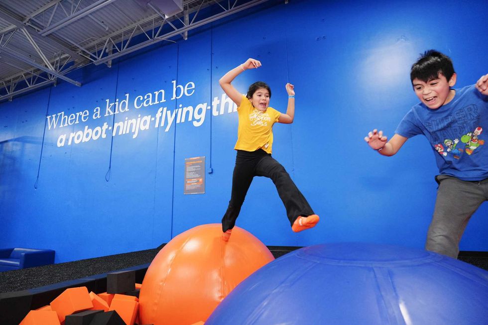 Two kids jumping on giant rubber balls
