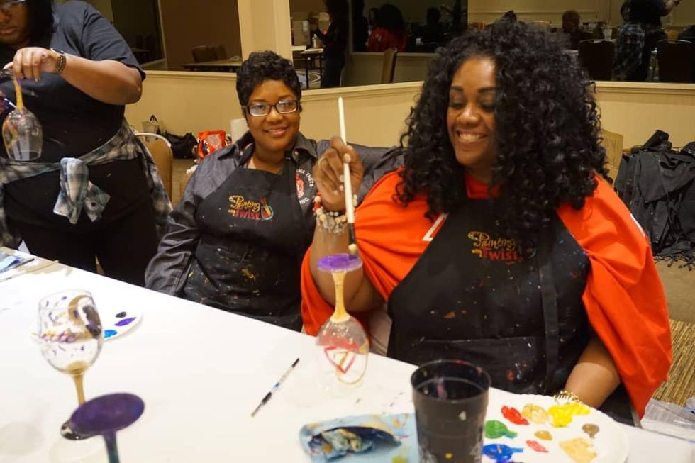 Two women painting wine glasses