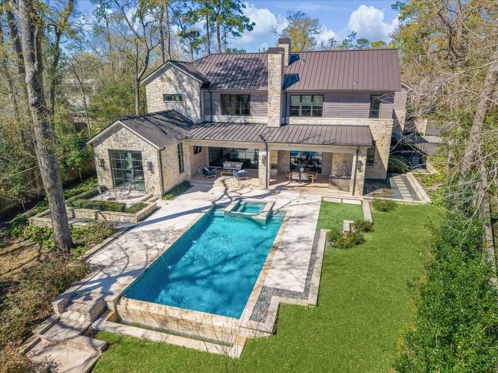 View of the backyard of 314 Hunters Trail, showing the pool and wooded grounds