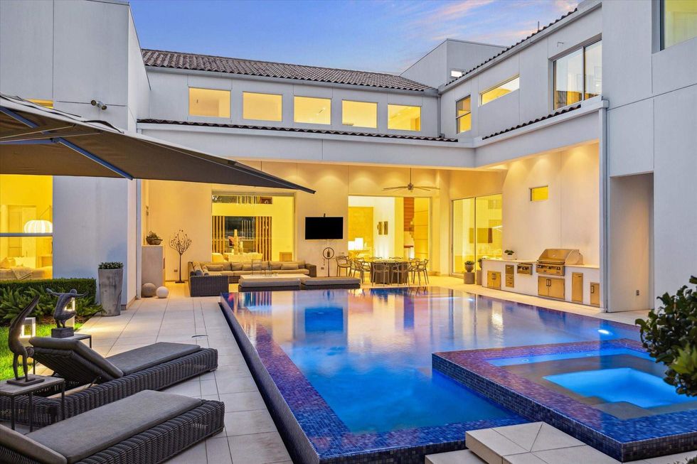 View of the backyard pool, spa and outdoor kitchen of 311 Brown Saddle St.