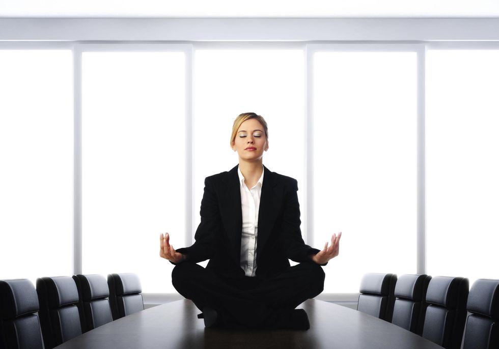 Woman in business suit meditation