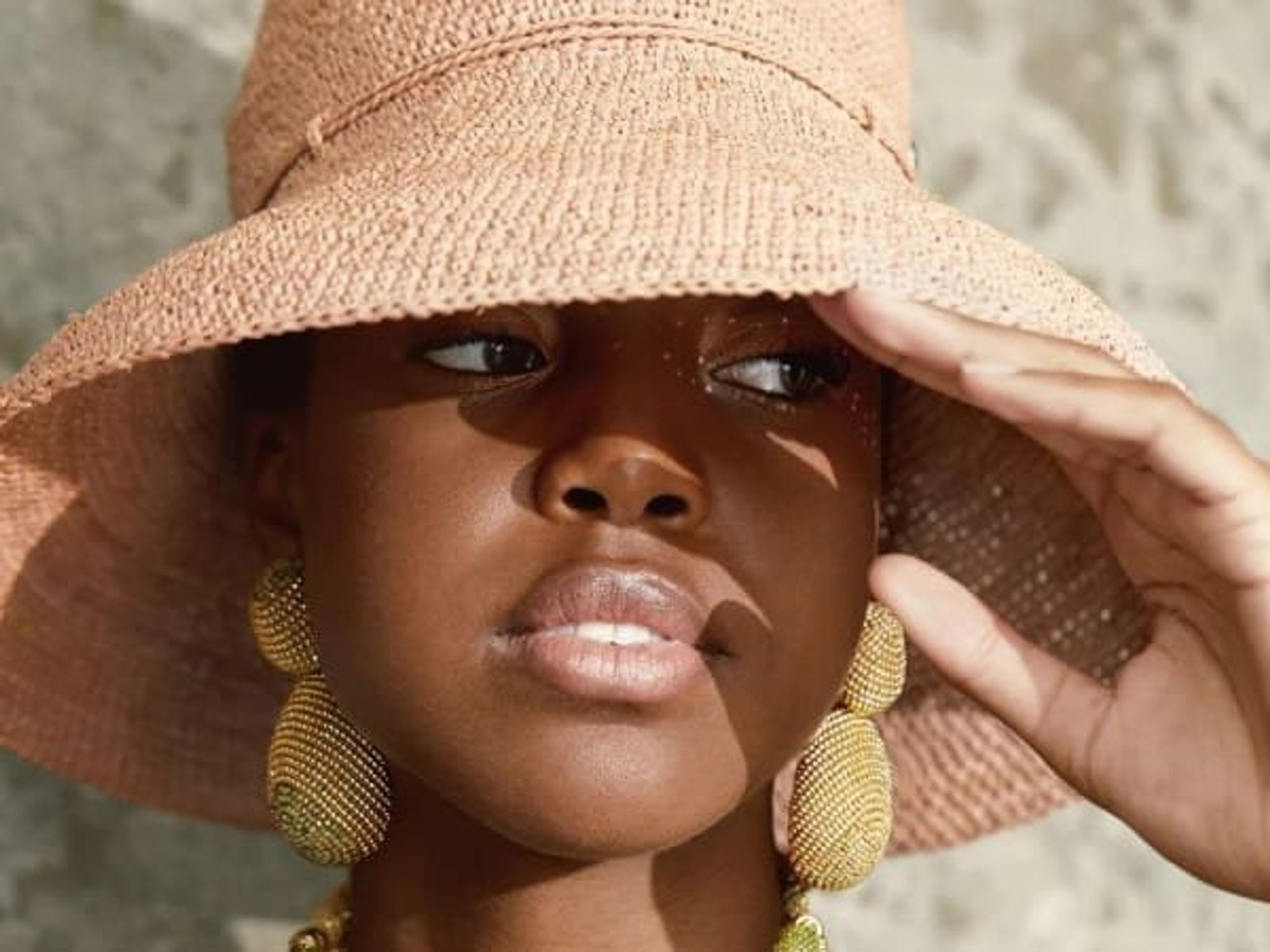 woman in sun hat and beaded jewelry