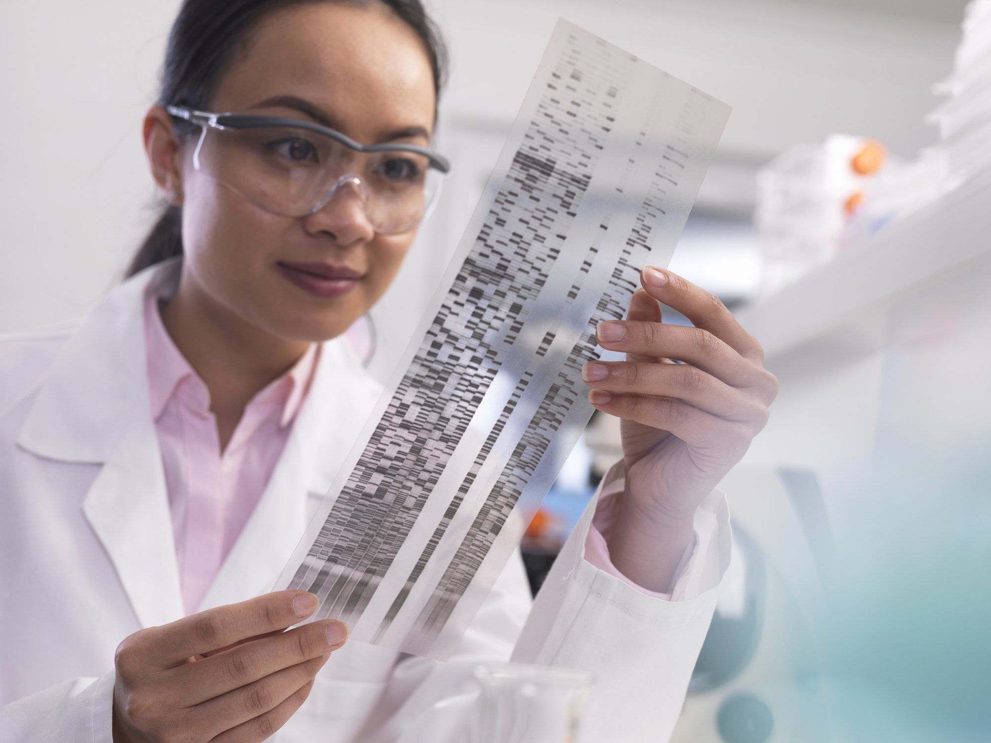 Woman in white coat studying genome panel