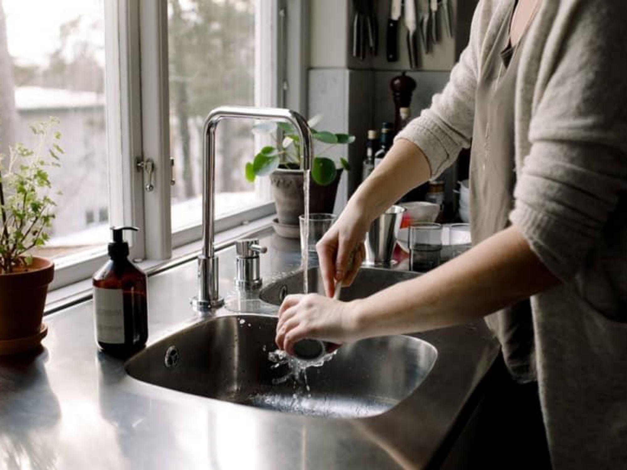 Woman washing dishes in the sink