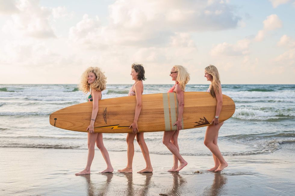 Women on beach with surfboard Port Aransas